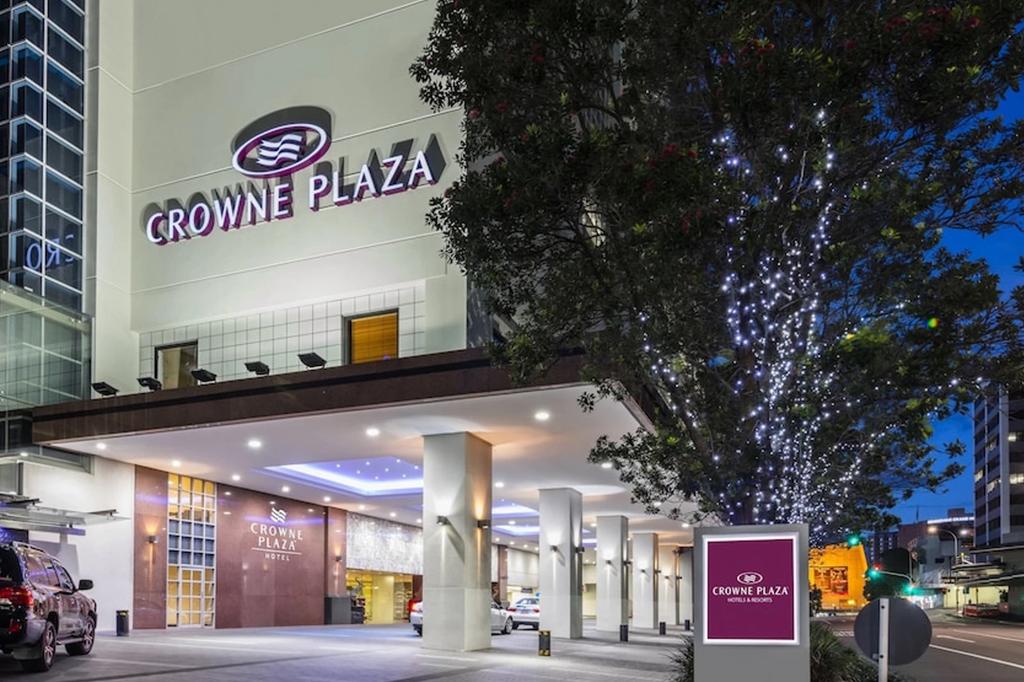Exterior of Crowne Plaza Auckland at dusk with city lights.