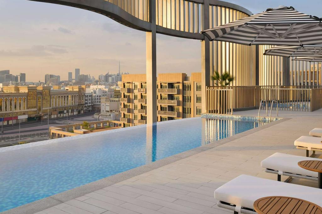 Rooftop infinity pool with city views at a stylish Dubai hotel.