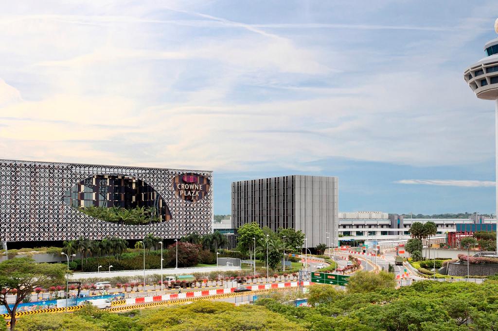 View of Crowne Plaza Changi Airport with control tower nearby.