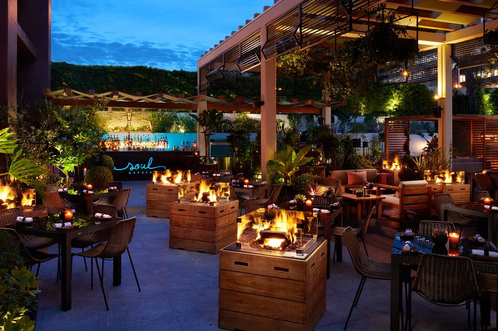 Stylish outdoor seating area at Soul Garden, with fire features and lush greenery.