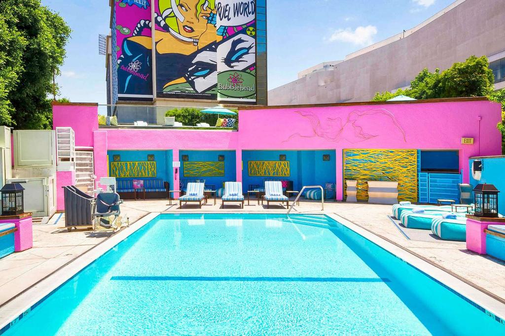 Vibrant hotel pool area with colorful walls and lounge chairs.