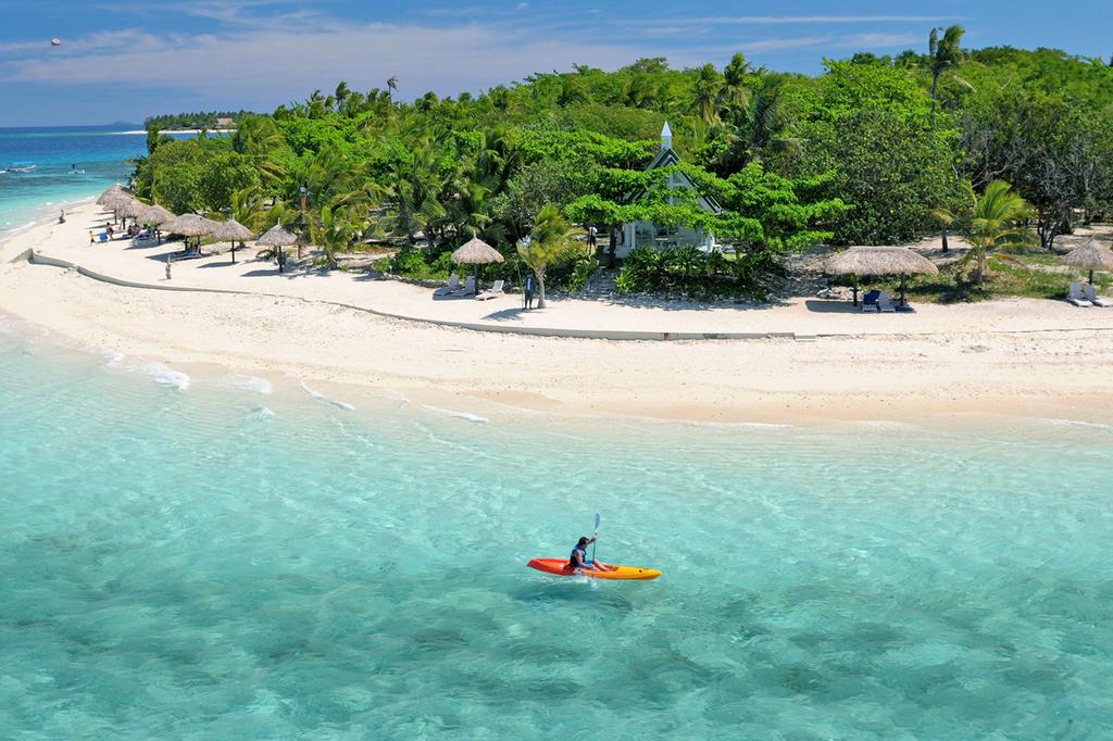 Scenic view of Treasure Island, Fiji with a beach and kayak on clear water.