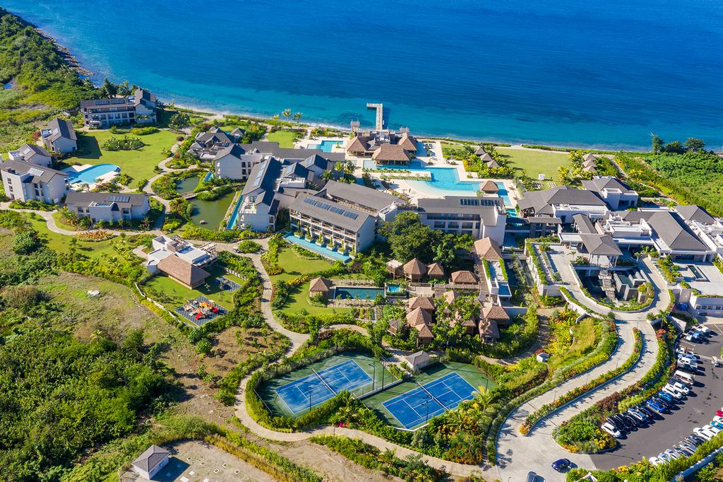 Aerial view of a Caribbean beachfront resort surrounded by greenery and ocean.