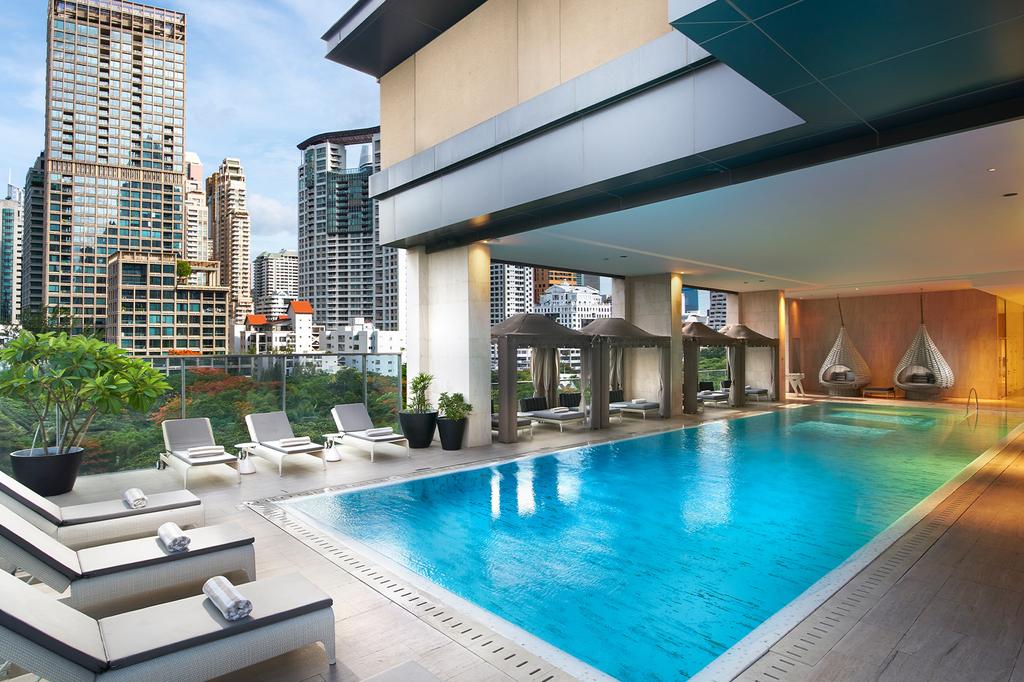 Luxurious rooftop infinity pool in a Bangkok all-suite hotel.