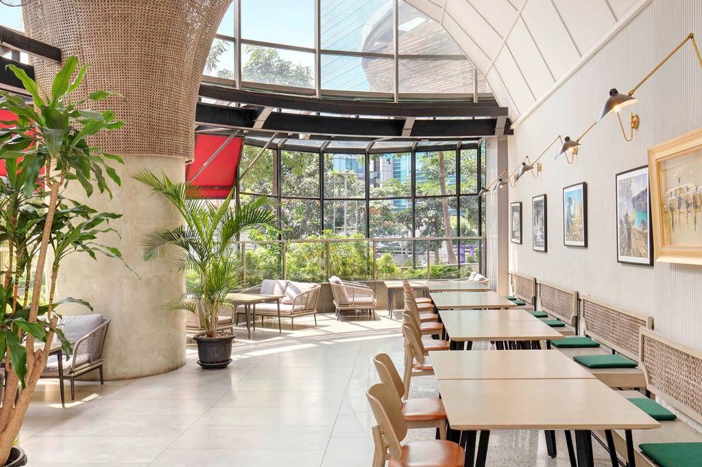 Bright restaurant interior at South Jakarta Mercure with large windows and plants.