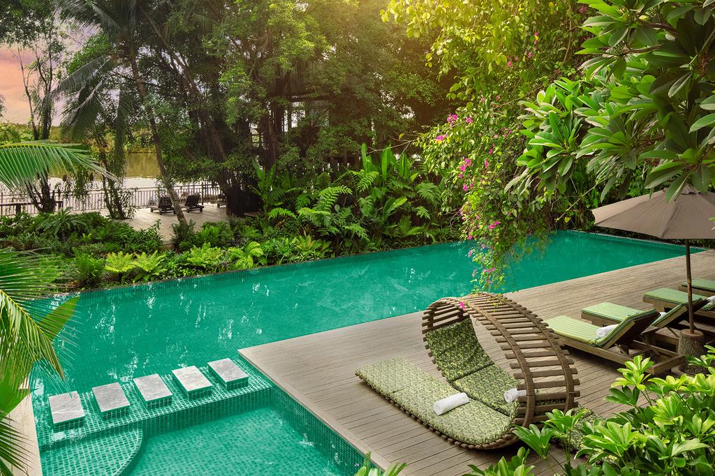 Tranquil poolside area with lush greenery at An Lam Retreats Saigon River.