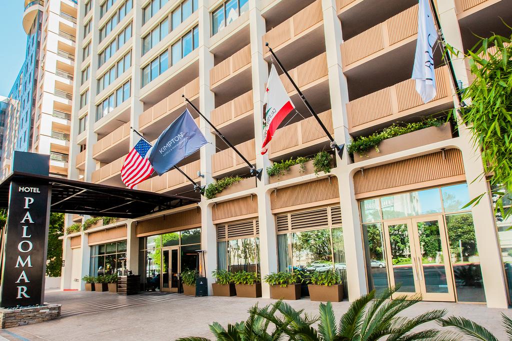 Entrance of Kimpton Hotel Palomar Beverly Hills with flags displayed.