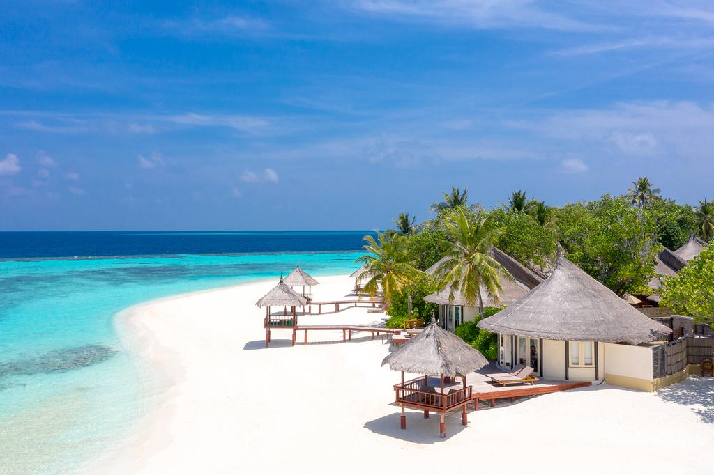 A beachfront resort in the Maldives with white sands and clear blue waters.