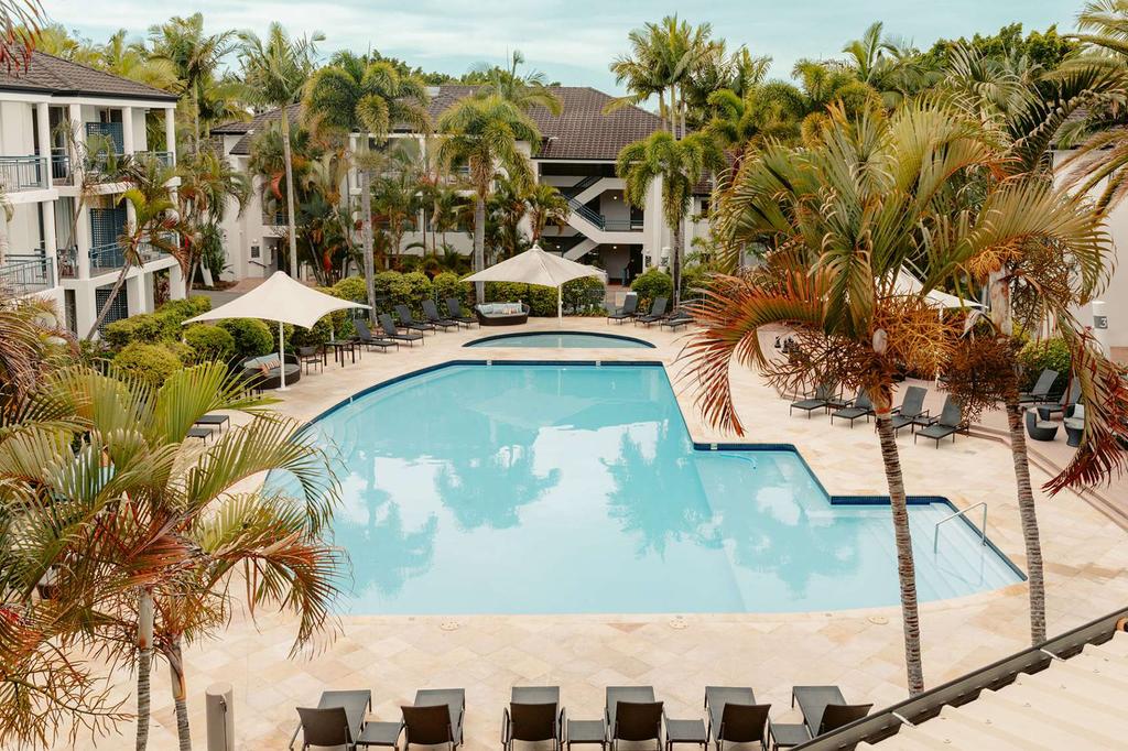Luxurious pool area at the Gold Coast Mercure hotel with palm trees.