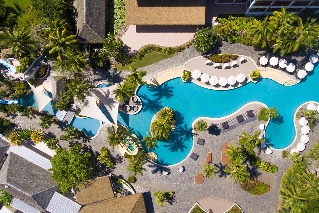 Aerial view of Sofitel Fiji's sprawling pool area with lush greenery.
