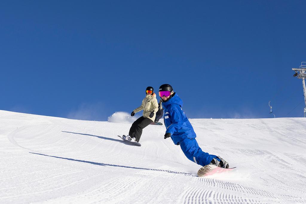 Two snowboarders enjoying the slopes at Perisher Valley.