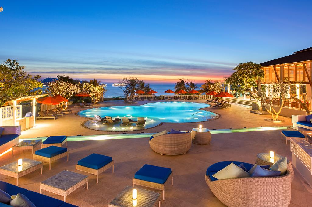 Luxurious oceanfront resort in Phuket with pool and sunset views. 