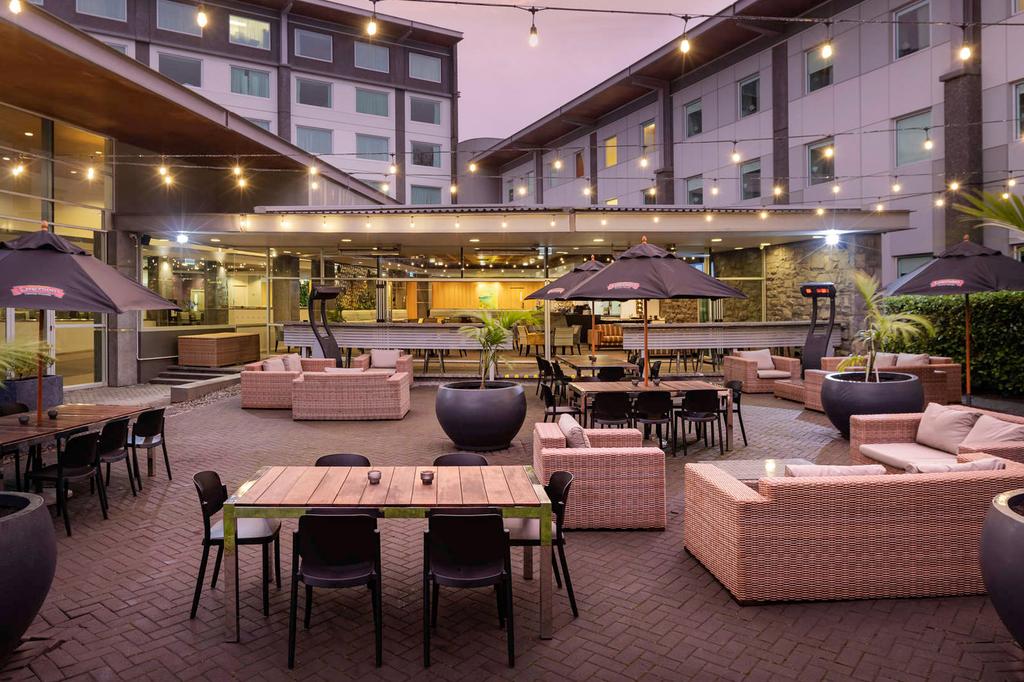 Outdoor seating area with string lights at hotel garden bar in Auckland.