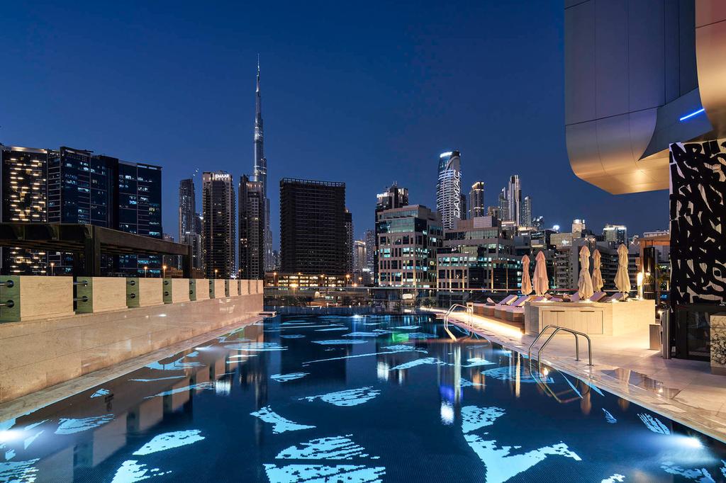 Rooftop pool with Burj Khalifa views in Dubai's Business Bay district.