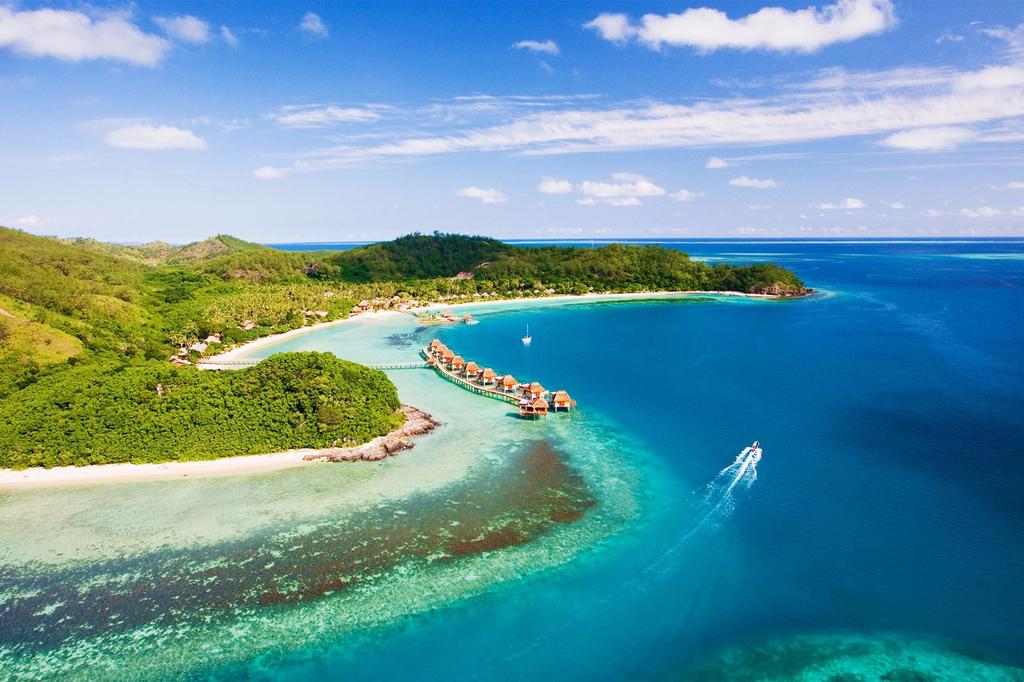 Aerial view of luxury Fijian resort over turquoise lagoon on Malolo Island.