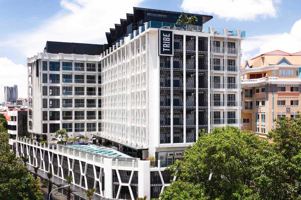 Exterior view of a chic hotel in Phnom Penh with a rooftop pool.