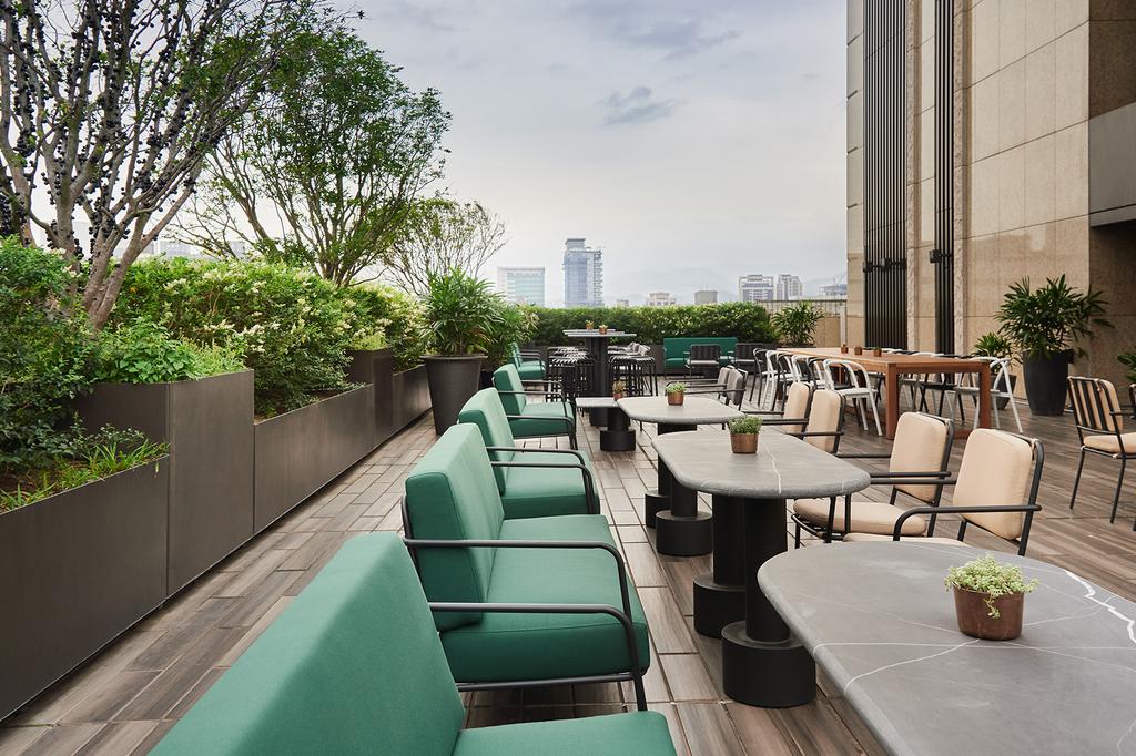 Rooftop terrace at Kimpton Da An Hotel with city skyline views.
