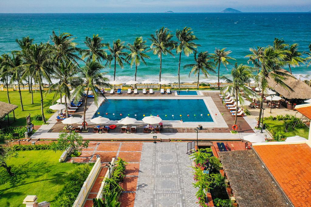 Beachfront resort with pool, palm trees, and ocean view in Hoi An.