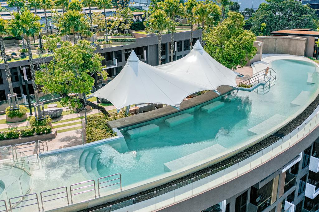 Aerial view of luxury rooftop pool surrounded by lush greenery.