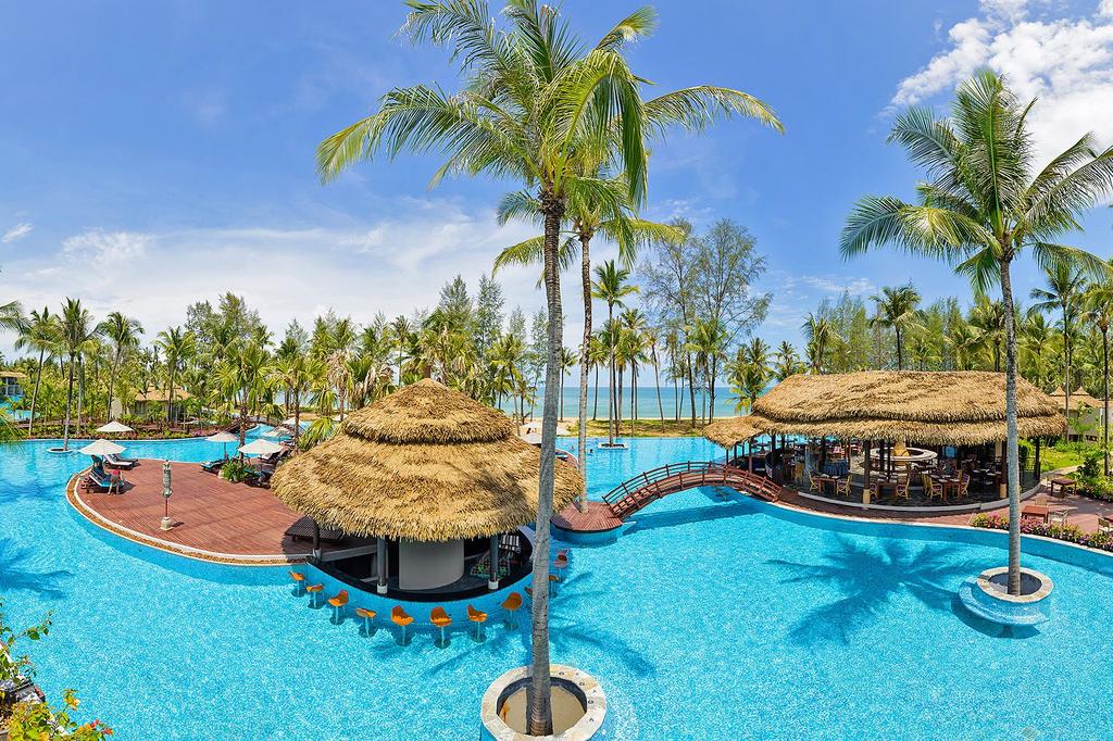 A luxurious resort with a large pool and beachside view.