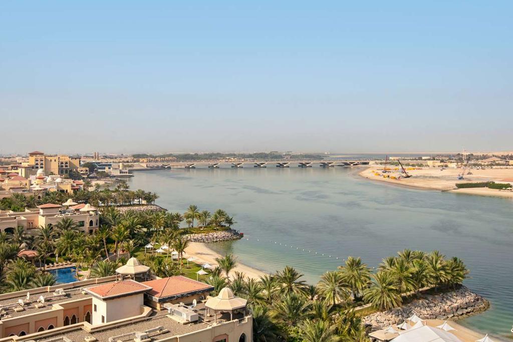 Aerial view of luxury Abu Dhabi resort with beachfront and palm trees.