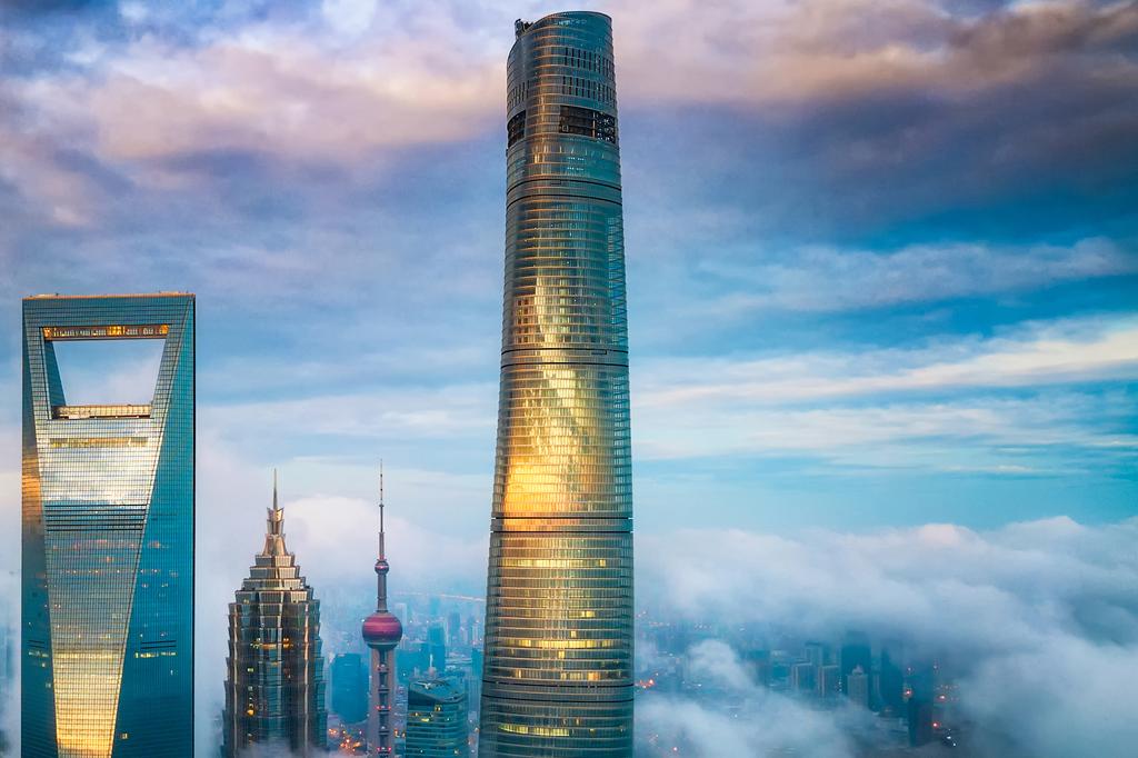 Shanghai Tower rising above the clouds in Shanghai's skyline.