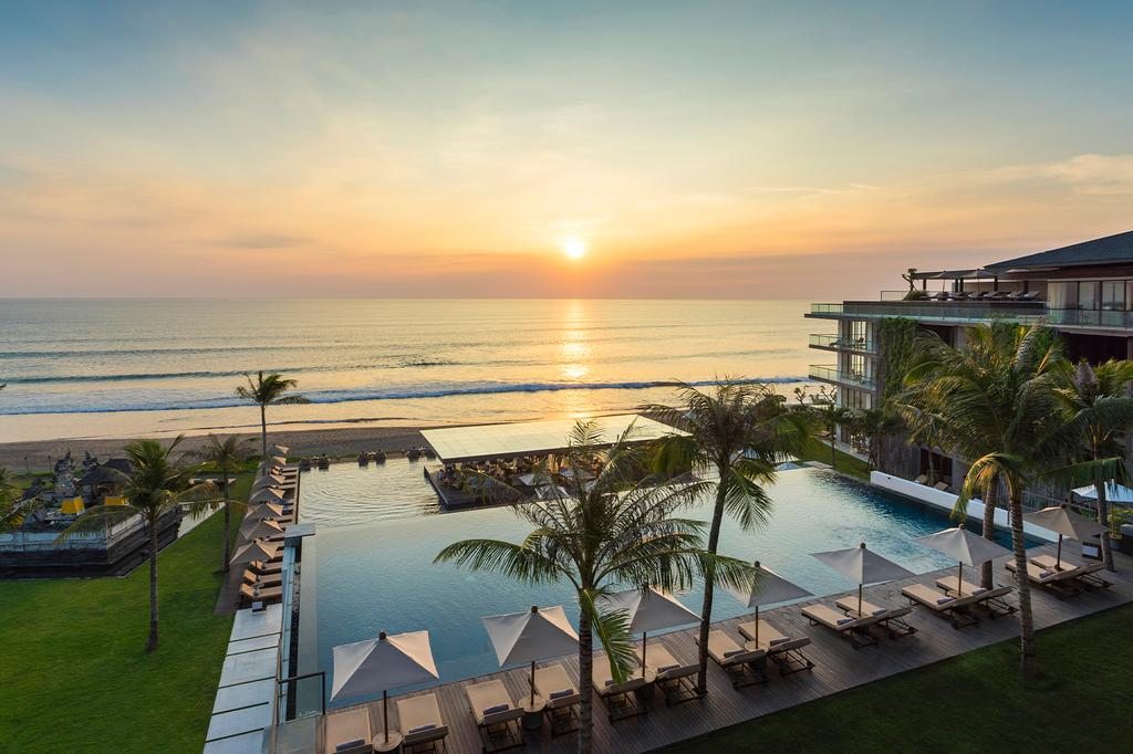 Beachfront resort with pool overlooking a sunset view in Seminyak.