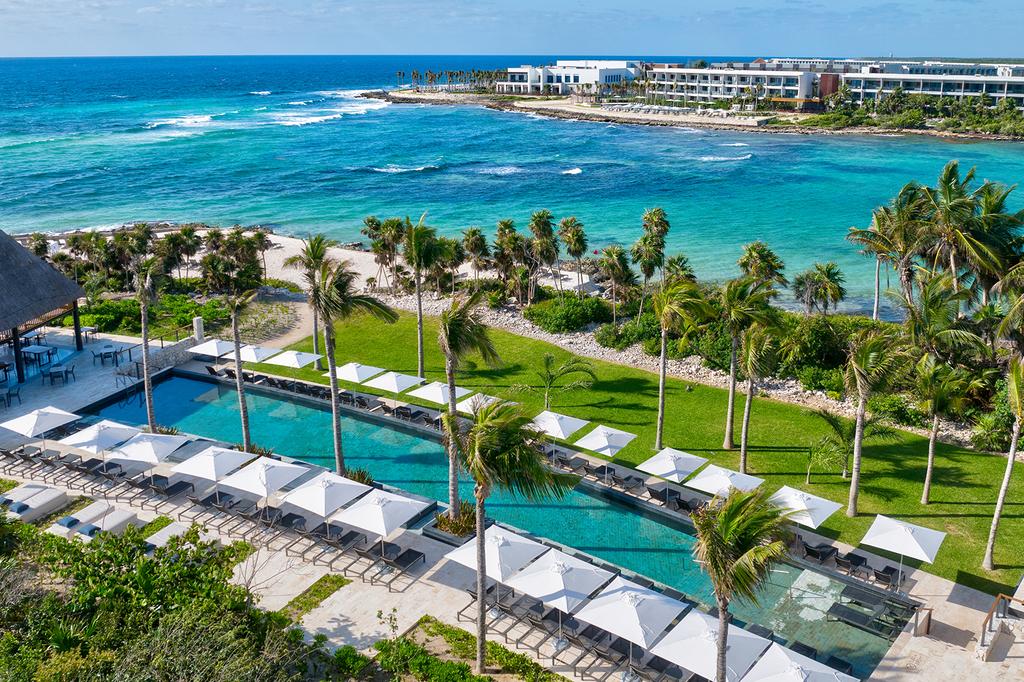 Aerial view of a luxury beachfront resort with pools in Riviera Maya