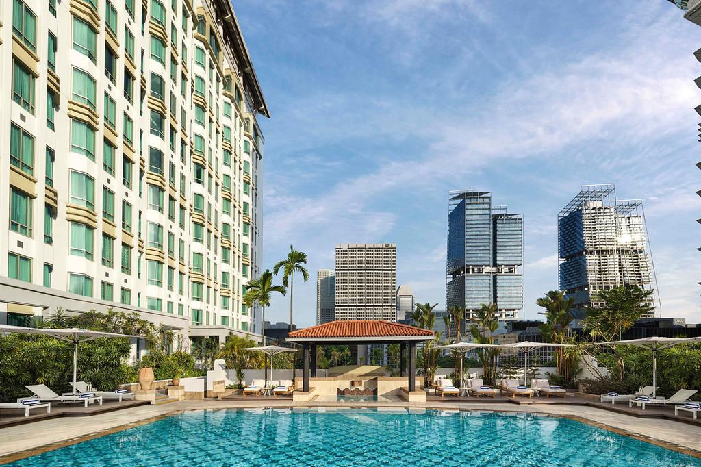 Rooftop pool and bar at InterContinental Singapore, an IHG Hotel, with city skyline view.