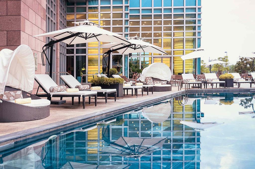 Outdoor pool with lounge chairs and umbrellas at a stylish Danang resort.