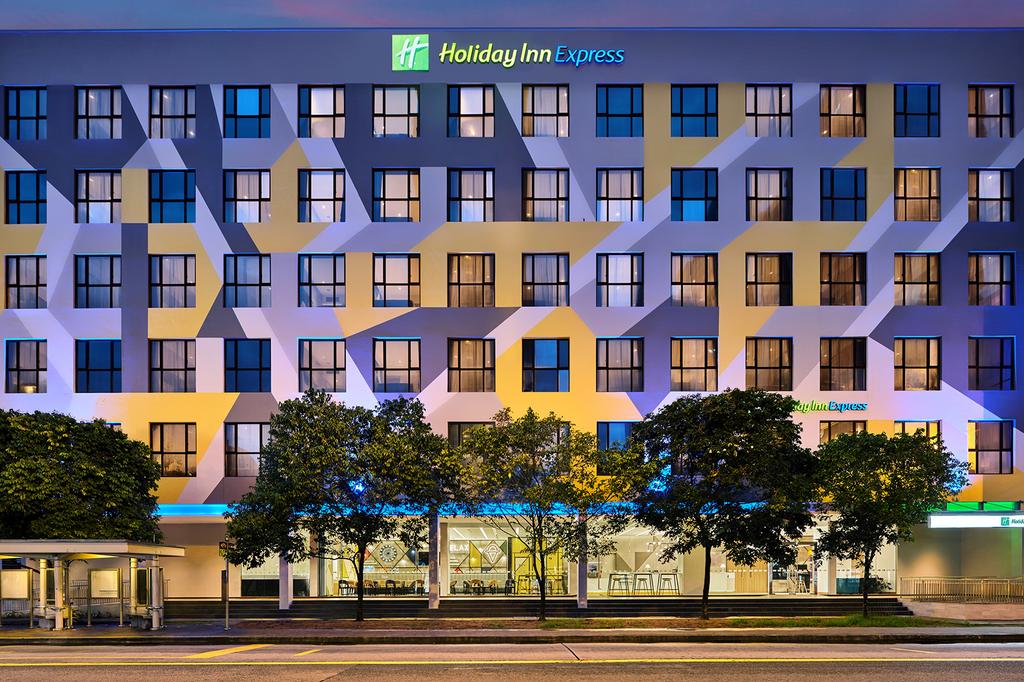 Holiday Inn Express Singapore Serangoon with colourful facade at dusk.