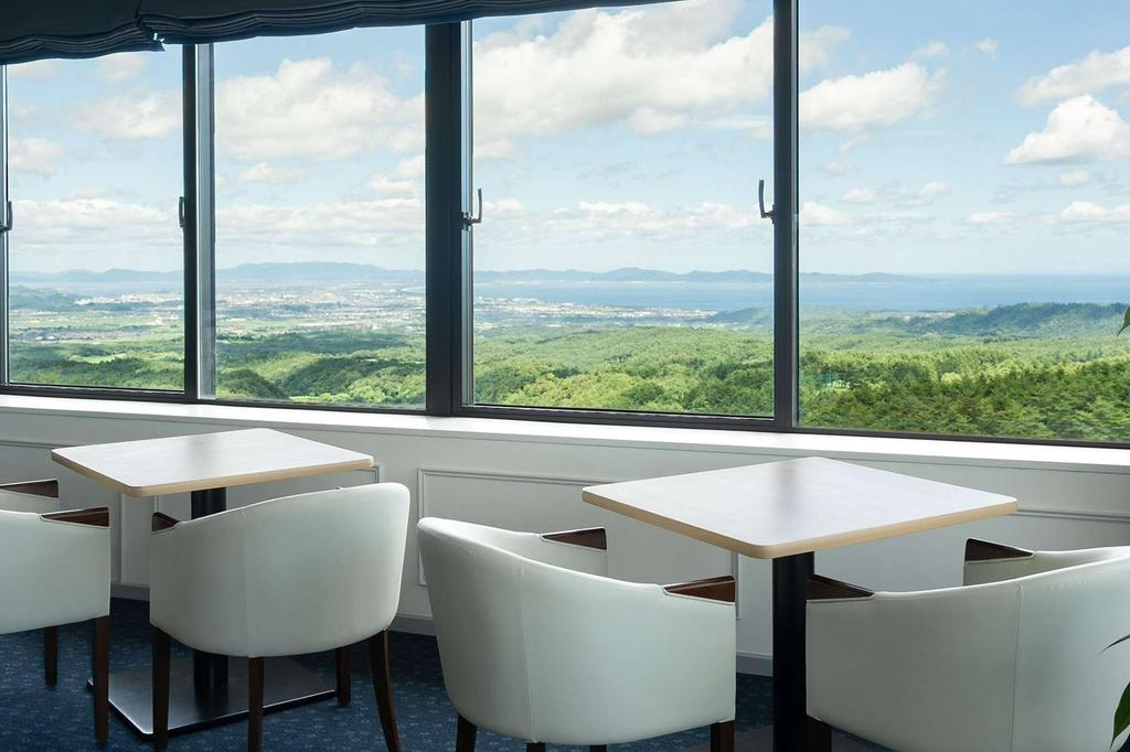 Dining area with panoramic views of Daisen Mountains and lush greenery.