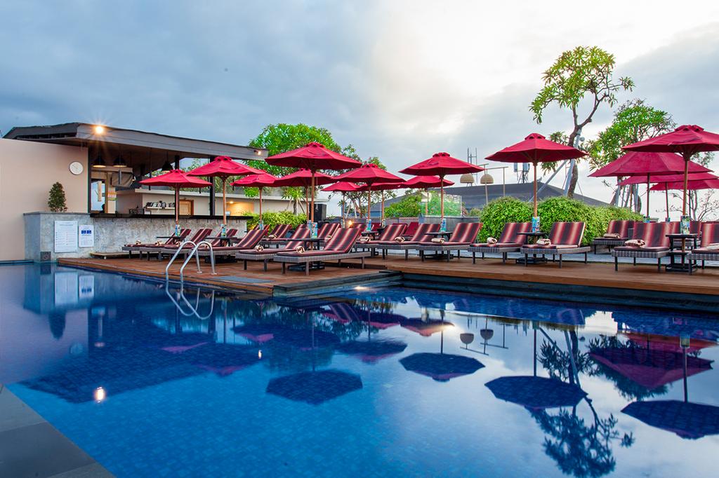 Infinity pool with red umbrellas at SEVN Legian in Bali