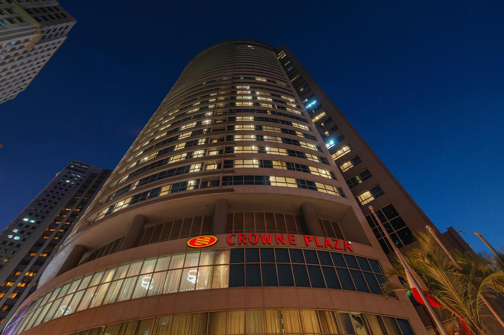 Crowne Plaza Manila Galleria skyscraper in the heart of Ortigas Center at dusk.