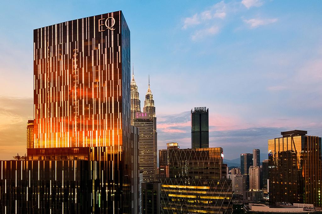 Skyline view of KL with EQ Kuala Lumpur and Petronas Towers at sunset. 