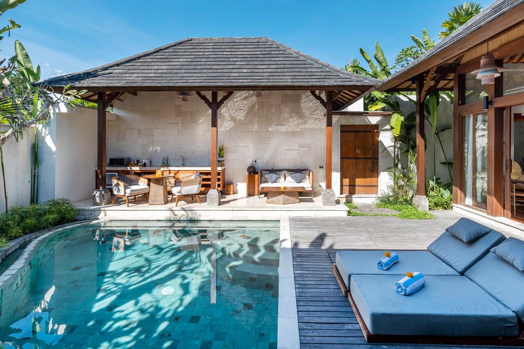 Private villa with pool and lounge chairs at Asvara Villa Ubud.