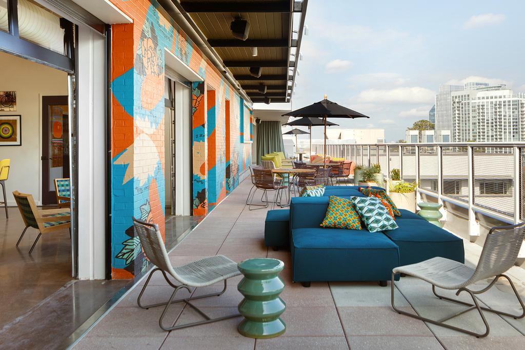 Rooftop seating area at Kimpton Sylvan Hotel with Atlanta skyline view.