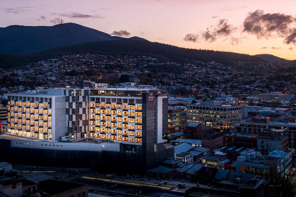 Exterior of Crowne Plaza Hotel, an IHG Hotel at sunset with mountain backdrop.