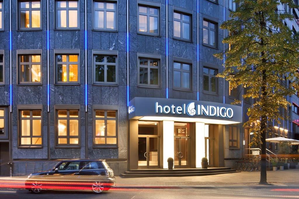 Hotel Indigo Berlin entrance illuminated at night with modern facade.