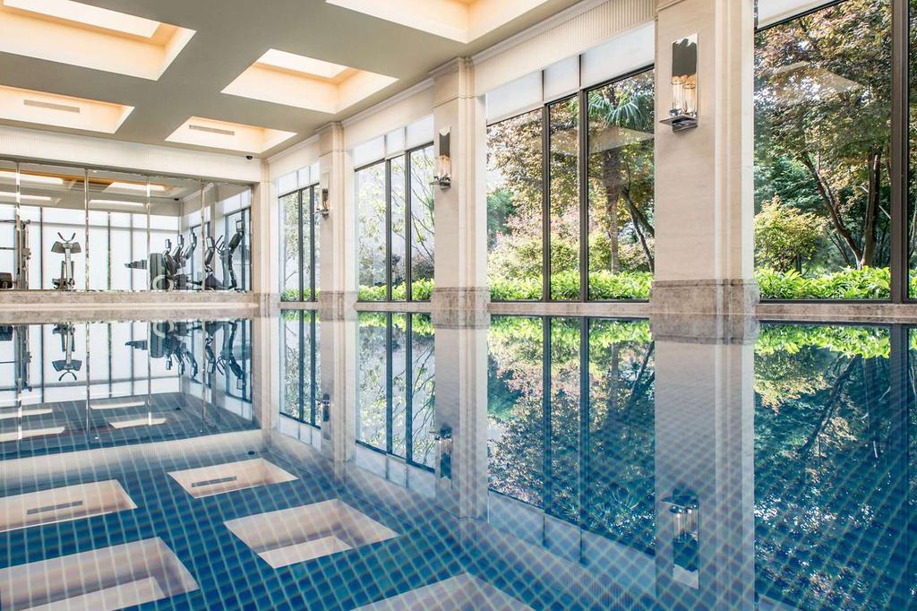 Indoor pool with large windows and garden views at a luxury hotel.