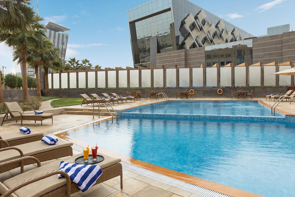 Glamorous outdoor pool at Crowne Plaza Riyadh with modern architecture backdrop.