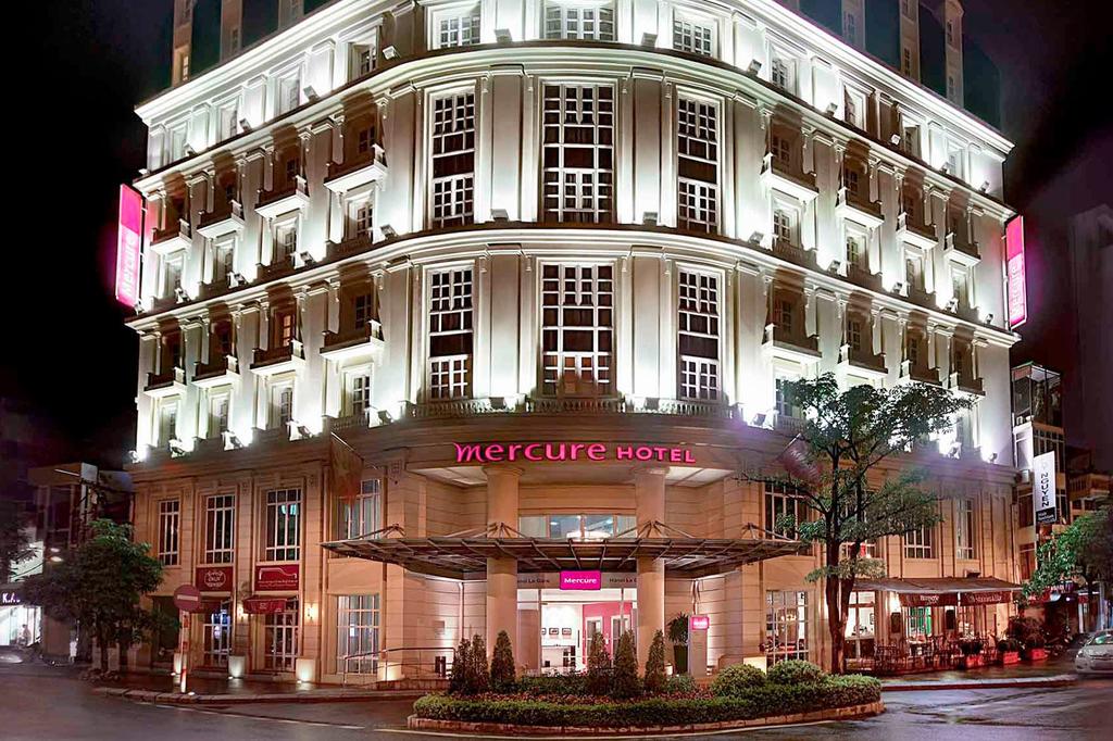 Elegant hotel exterior lit up at night in central Hanoi.
