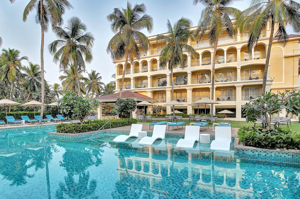 Oasis-style pool surrounded by palm trees at Holiday Inn Goa Candolim.