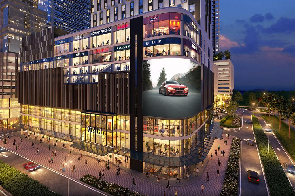 Modern hotel exterior with shops and illuminated sign at night.