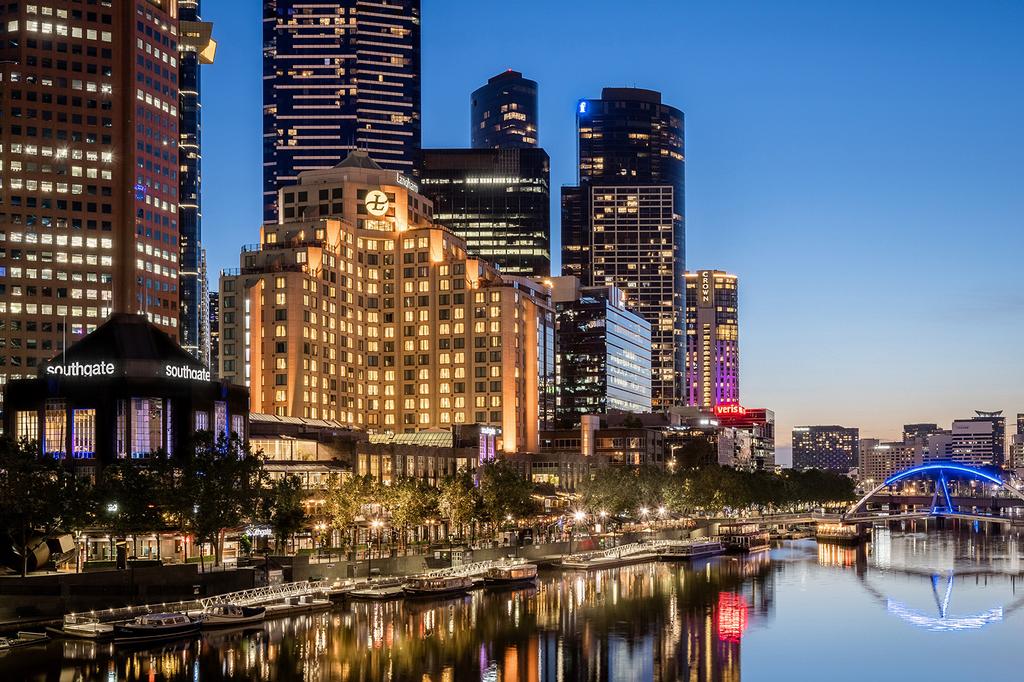 The Langham Melbourne exterior along the Yarra River with city skyline