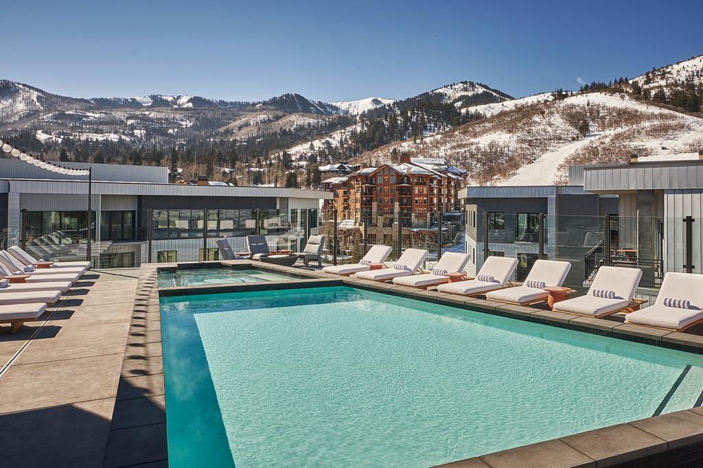 Luxury ski resort with pool and mountain views.