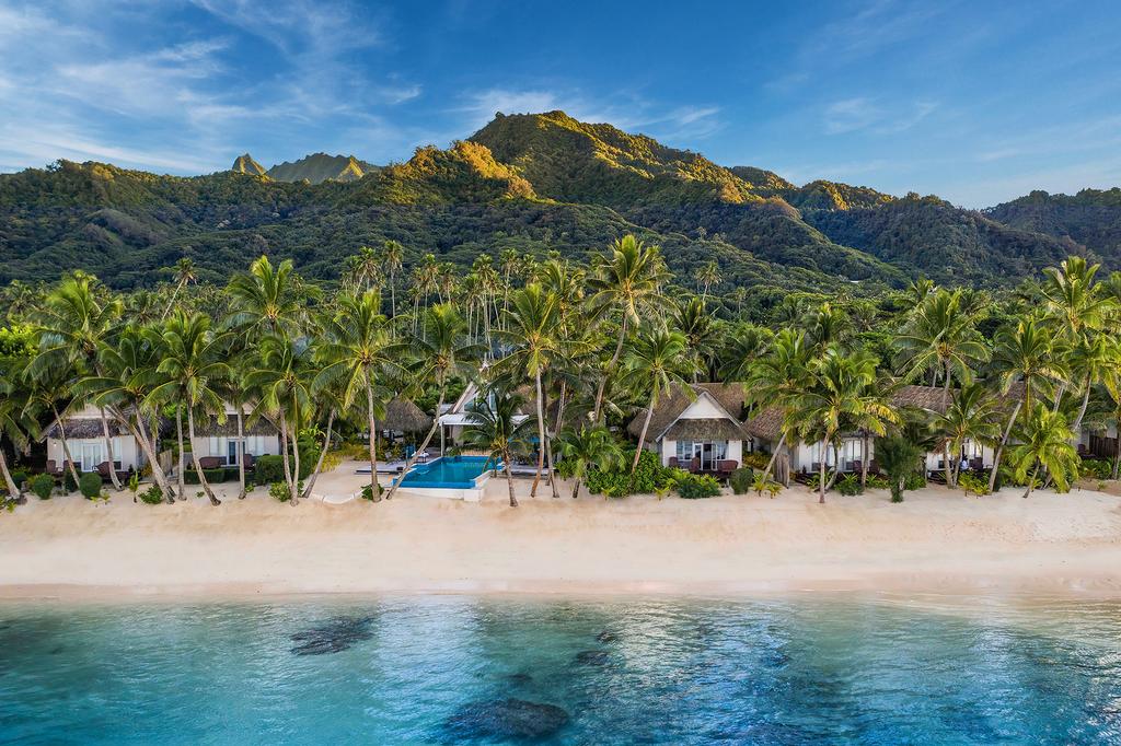 Beachfront bungalows set in lush surroundings at Little Polynesian Resort, on a pristine Cook Islands beach. 