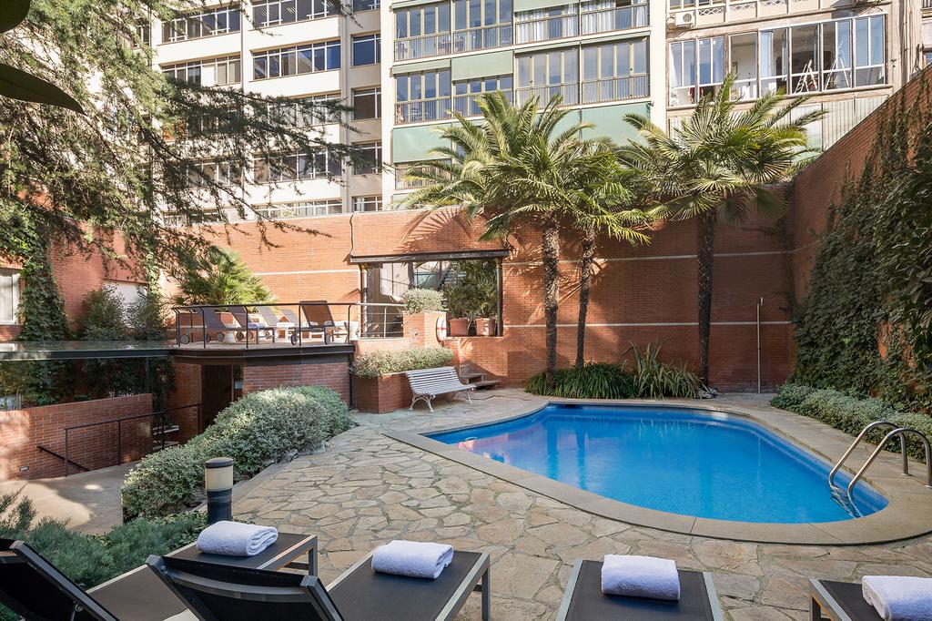 Tranquil pool and garden area at the Hotel Balmes in Barcelona.