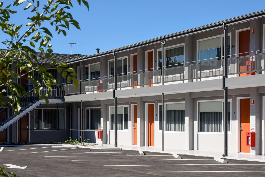 Modern Adelaide motel overlooking leafy parklands with orange doors.