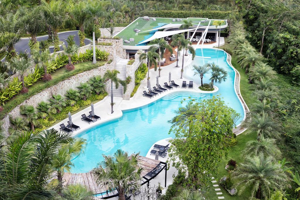 A hilltop resort in Phuket with a large pool and lush gardens.